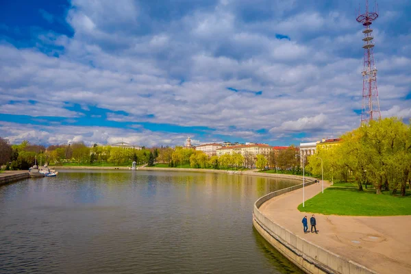 Personas no identificadas caminando en la frontera del lago con un hermoso paisaje con el río Svisloch en el Parque de la Victoria en Minsk —  Fotos de Stock