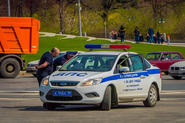 मॉस्को, रूस-अप्रैल, 24, 2018: रूस में मॉस्को में एक धूप के दिन रेड स्क्वायर पर ड्राइविंग करने वाली पुलिस कार के अंदर अज्ञात आदमी का आउटडोर दृश्य — स्टॉक फ़ोटो, इमेज