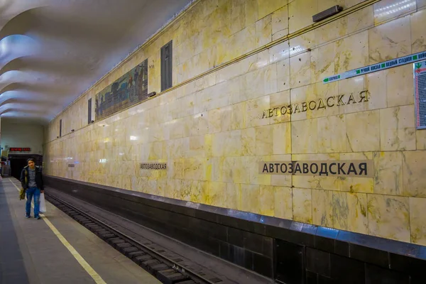 MOSCOW, RUSSIA- APRIL, 24, 2018: Indoor view of unidentified blurred man with a plastic bag in his hand, waiting the train inside of underground train station with empy rails — Stock Photo, Image