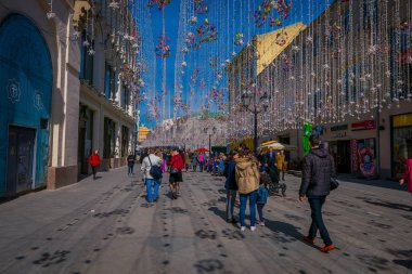 Moskova, Rusya - Nisan, 24, 2018: insanlar Nikolskaya sokakta şenlikli bir Noel ışıkları ile alanında birçok Hediyelik eşya dükkanı
