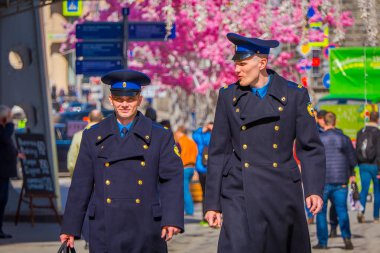 Moskova, Rusya - Nisan, 24, 2018: güneşli bir günde Nikolskaya sokaklarda üniforması ve şenlikli bir Noel altında yürüyen iki adamın açık görünüm ışıklar