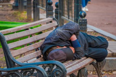 Moskova, Rusya - Nisan, 29, 2018: açık görünümünü tanımlanamayan evsiz adam Moskova'da bir parkta genel bir sandalyede uyuyor