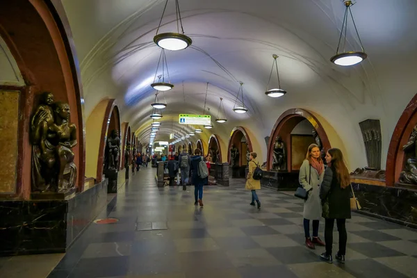 МОСКВА, РОССИЯ - 29 апреля 2018 года: Внутренний вид неопознанных людей, идущих близко к бронзовой скульптуре на станции метро "Площадь Революции" — стоковое фото