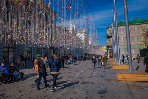 Moskva, Ryssland - April, 24, 2018: människor i en festlig julbelysning på Nikolskaya gata med många souvenirbutik i området — Stockfoto