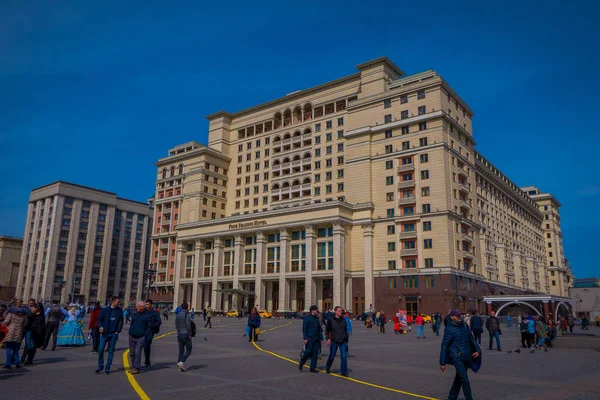 MOSCOW, RUSSIA- APRIL, 24, 2018: Unidentified people walk on Manezhnaya Square near famous prestigious building of Four Seasons Hotel Moscow — Stock Photo, Image