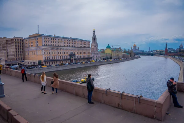 MOSCOU, RUSSIE - 24 AVRIL 2018 : Vue extérieure de personnes non identifiées marchant et prenant des photos dans le remblai de Kadashevskaya, point de repère par une journée nuageuse avec un paysage urbain derrière à Moscou — Photo