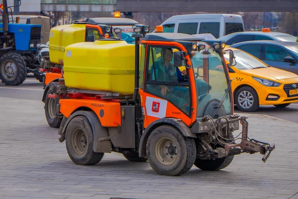 MOSCÚ, RUSIA - 24 DE ABRIL DE 2018: Vista al aire libre del hombre conduciendo una máquina de limpieza lavando el pavimento con agua después del evento en las calles de Moscú —  Fotos de Stock