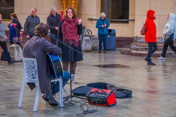 MOSCOW, RÚSSIA- ABRIL, 24, 2018: Vista ao ar livre do músico tocando uma guitarra eletrônica na calçada, com algumas pessoas desfrutando da performance durante uma celebração da Páscoa — Fotografia de Stock