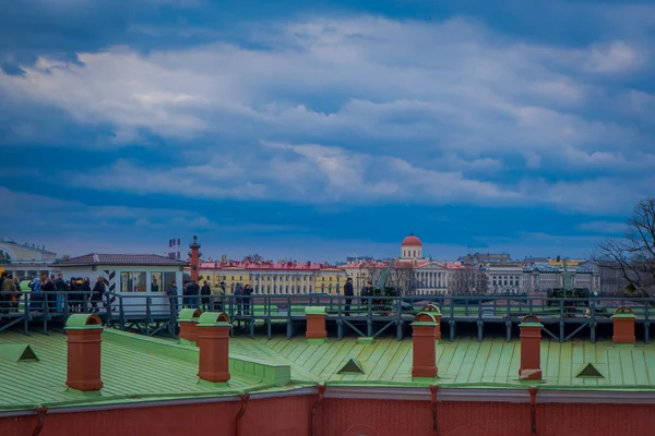 ST. PETERSBURG, RUSSIA, 17 MAY 2018: Outdoor view of unidentified people walking in a green rooftop close to old artillery guns near the Naryshkin bastion, with rostral column behind — Stock Photo, Image