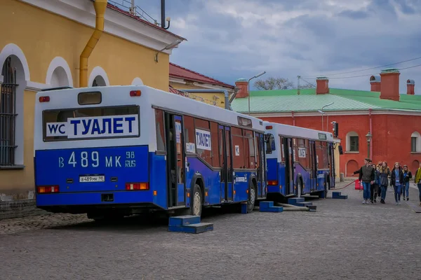 ST. PETERSBURG, RUSIA, 17 DE MAYO DE 2018: Vista al aire libre de personas no identificadas caminando cerca de Bus en el estacionamiento en San Petersburgo — Foto de Stock