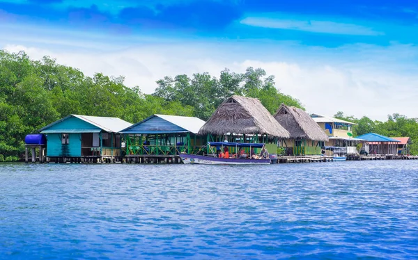 BOCAS, PANAMÁ - 20 DE ABRIL DE 2018: Vista al aire libre del turista en un barco cerca de casas de madera en la orilla de la isla de Colón en Bocas del Toroin el Caribe Oeste — Foto de Stock