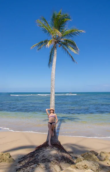 BOCAS DEL TORO, PANAMA - APRIL 20, 2018: Unidentified woman posing over a palm tree, in a gorgeous sunnny day with amazing background ladscape of the beach island — Stock Photo, Image