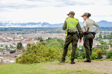 POPAYAN, COLOMBIA - FEBRUARY 06, 2018: Outdoor view of unidentified people wearing uniform police and enjoying the view of the city of Popayan, is the center of the department of Cauca clipart