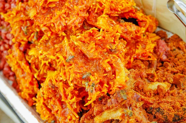 Close up of cocada, a traditional coconut dessert sold usually on the streets, made of grated coconut and brown sugar, which gives it the dark color — Stock Photo, Image