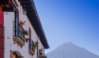 Çiçek gündoğumu sırasında binanın arka planda agua volcano ile antik Antigua şehir ana caddede bir tencerede balkona açık görünüm