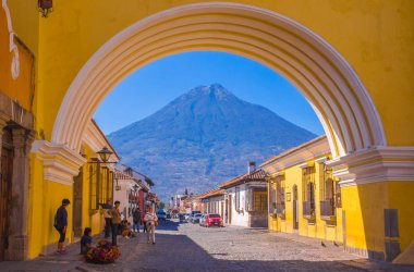 Ciudad de Guatemala, Guatemala, Nisan, 25, 2018: antigua şehrin sokaklarında ve görünümünde renkli sarı kemer ile arka planda etkin Agua volkanın yürüyen Tanımlanamayan kişi