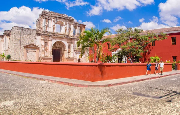 Ciudad de Guatemala, Guatemala, április, 25, 2018: azonosítatlan ember sétál az utcán, közel a régi épület szerkezete egy narancssárga kerítés Antigua szabadtéri nézet — Stock Fotó