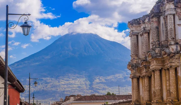 Ciudad de guatemala, guatemala, 25. april 2018: Außenansicht der durch das Erdbeben zerstörten Kathedrale in Antigua-Guatemala mit geschnitzten Säulen und Vulkanberg dahinter — Stockfoto