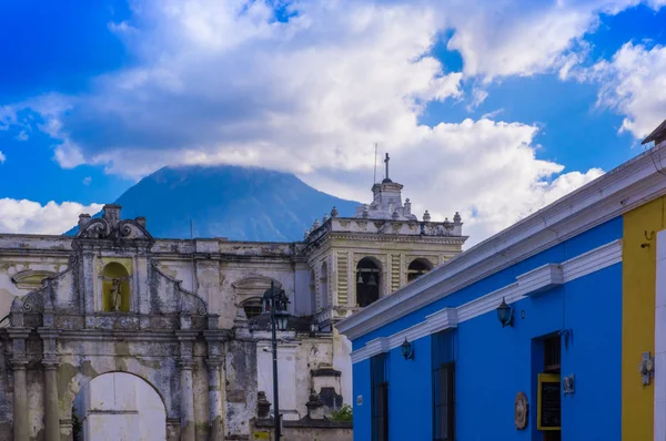 Ciudad de Guatemala, Guatemala, 25 aprile 2018: Veduta di vecchi edifici distrutti con un edificio a muro blu nelle strade di Antigua Guatemala, città storica Antigua è patrimonio dell'umanità dell'UNESCO — Foto Stock