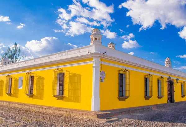 Ciudad de Guatemala, Guatemala, 25 de abril de 2018: Vista al aire libre de la perspectiva de esquina de una casa colonial de color amarillo brillante con ventanas con rejas en la ciudad de Antigua —  Fotos de Stock