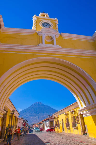 Ciudad de Guatemala, Guatemala, April, 2018: The colorful yellow arch of Antigua city with the active Agua volcano in the background, Guatemala — стоковое фото
