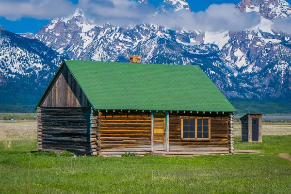 Außenansicht der Holzhütte mit grünem Dach auf einem goldenen Gras Prärie gegen den Grand Teton Berge, Nationalpark, wyoming — Stockfoto