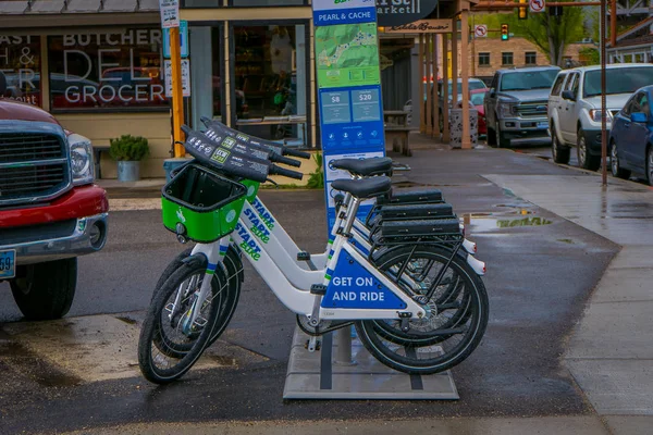 JACKSON HOLE, WYOMING, EE.UU. - 23 DE MAYO DE 2018: Vista al aire libre de las bicicletas estacionadas en una fila, ubicadas en un sitio de alquiler de bicicletas en una zona de estacionamiento al aire libre en la calle principal de la ciudad en Jackson Hole — Foto de Stock