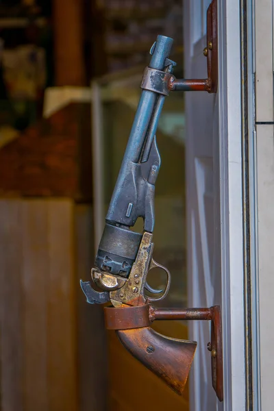 Close-up de foco seletivo de uma arma pendurada em uma parede dentro de um edifício no centro de Jackson Hole — Fotografia de Stock