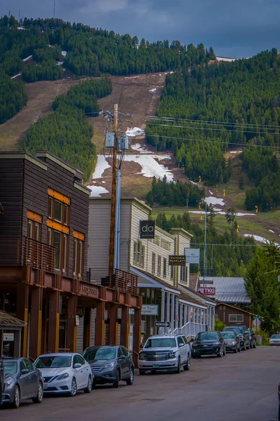 Jackson Hole, Usa - 23. května 2018: venkovní pohled na lyžařské svahy v Jackson Hole hory za nádherné domy budov s auta zaparkovaná na jedné straně vozovky — Stock fotografie