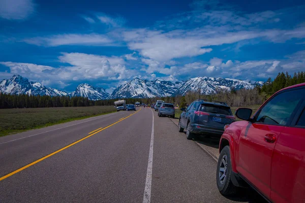 Widok zewnętrzny samochody zaparkowane na jednej stronie drogi od Parku Narodowego Yellowstone Park Narodowy Grand Teton, Wyoming — Zdjęcie stockowe