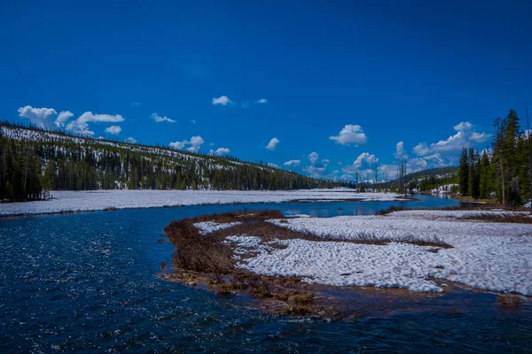 Vista al aire libre del río congelado parcial en el Parque Nacional de Yellowstone con cielo azul — Foto de Stock