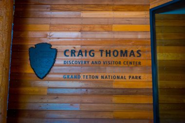 Jackson Hole, Wyoming ABD - 23 Mayıs 2017: kalkan ve Danışma Masası Craig Thomas keşif ziyaretçi merkezi içinde yer alan bir ahşap duvar harflerle açık Mart Kasım ayının başına kadar