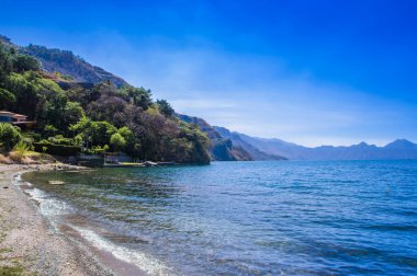 Lake Atitlan, kıyıda bir güzel güneşli gün ve Guatemala mavi su sırasında güzel açık görünümü