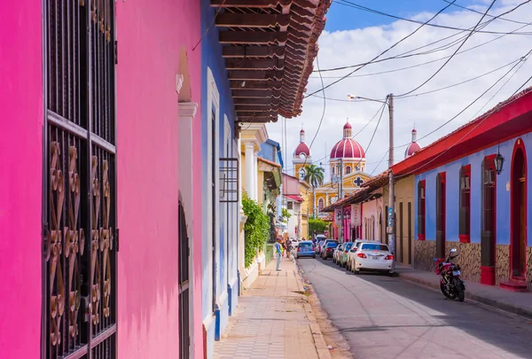 GRANADA, NICARAGUA, 14 MAGGIO 2018: Veduta esterna degli edifici della facciata con parete rosa, porta in legno e tetto in uno splendido sfondo azzurro nel centro storico di Granada — Foto Stock