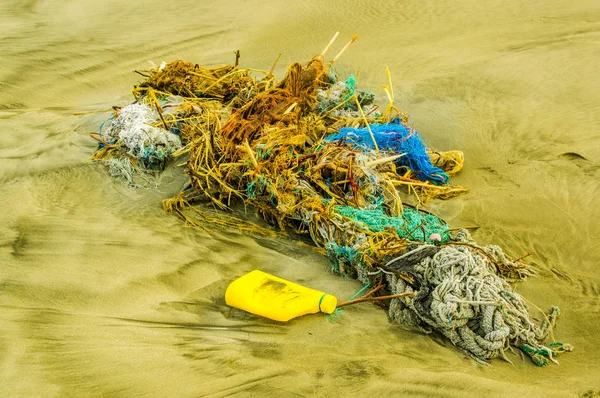 Buiten uitzicht op het net en touwen vuilnis in het strand vissen, elke dag afval hoopt zich op het strand van de oceaan stromingen effect — Stockfoto