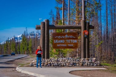 Yellowstone, Montana, ABD 24 Mayıs 2018: Grand Teton Yellowstone Milli Parkı'nda bilgilendirici bir iz içinde bekleyen kimliği belirsiz kadın