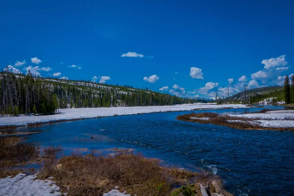 Vista al aire libre del río congelado parcial en el Parque Nacional de Yellowstone con cielo azul — Foto de Stock