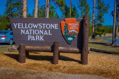 Yellowstone, Montana, ABD 24 Mayıs 2018: Bilgilendirici tabelada Yellowstone Milli Parkı park girin, ahşap yapı açık görünümünü