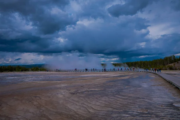 Vista al aire libre de los turistas caminando en un paseo marítimo en el horizonte, alrededor de la Gran Primavera Prismática en el Parque Nacional de Yellowstone, este géiser es uno de los más activos — Foto de Stock