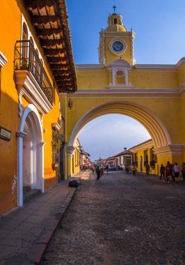 Ciudad de Guatemala, Guatemala, April, 25, 2018: Outdoor view of Santa Catalina arch and the main street of Antigua city at sunny day clipart
