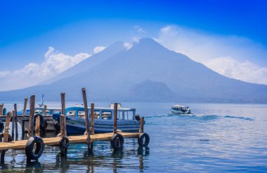 Panajachel, Guatemala-Nisan, 25, 2018: iskeleler içinde uzak köy San Pedro, lake Atitlan bir muhteşem gün boyunca arka planda Guatemala, tekneler.