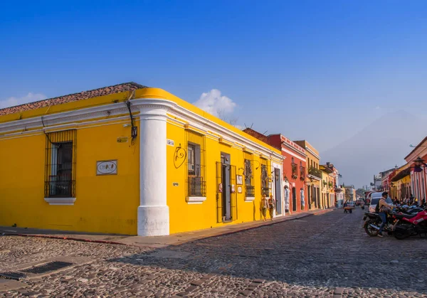 Ciudad de Guatemala, Guatemala, 25 de abril de 2018: Vista al aire libre de la perspectiva de esquina de una casa colonial de color amarillo brillante con ventanas con rejas en la ciudad de Antigua —  Fotos de Stock