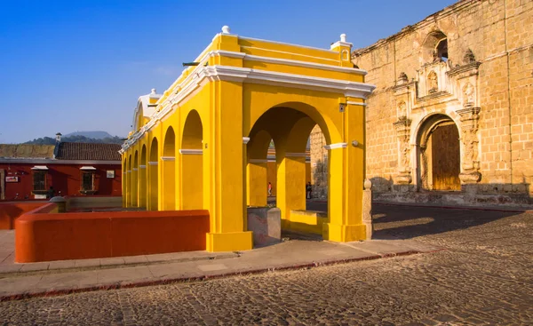 Ciudad de Guatemala, Guatemala, 25 de abril de 2018: Vista al aire libre de muchas columnas en una estructura de edificio amarillo ubicada en el centro de la ciudad, cerca de edificios antiguos en la ciudad de Antigua —  Fotos de Stock