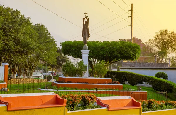 GUATEMALA Antigua Guatemala, 16 de diciembre de 2017: Vista al aire libre de la estatua de bronce del hermano Pedro con el volcán Agua al fondo, estatua de un religioso sosteniendo una cruz en la parte superior — Foto de Stock