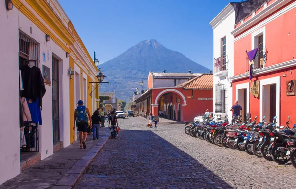 危地马拉, 危地马拉, 四月, 25, 2018: 石头 apvement 街和人们漫步和享受的安提瓜市的灿烂阳光明媚的一天和在危地马拉背景下的阿尔那火山 — 图库照片