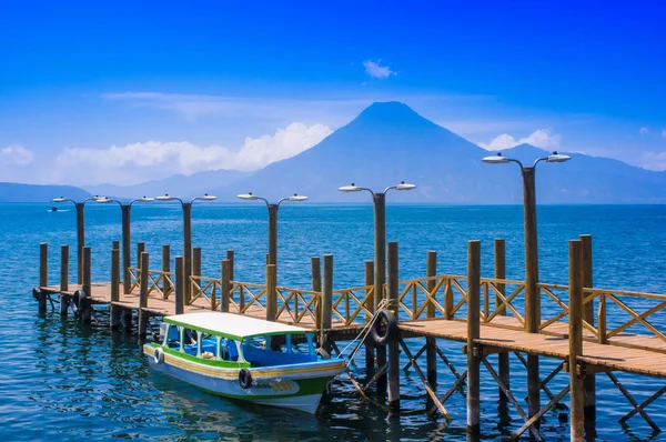 Panajachel, Guatemala - 25 de abril de 2018: Los muelles en Panajachel con el volcán San Pedro al fondo. Unos pocos botes pequeños están esperando a los turistas en la mañana para el tour del lago Atitlán — Foto de Stock