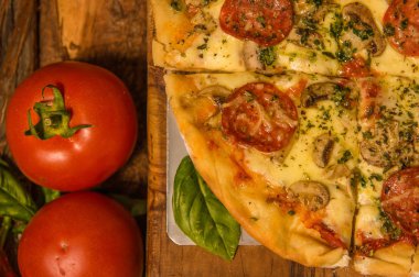 Yemek için evde ahşap masa arka plan üzerinde yakın lezzetli pizza domates görünümünün üzerinde hazır