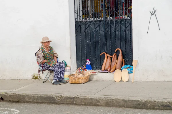 Popayan, kolumbien - 31. märz 2018: aussenansicht einer frau, die handarbeiten in den straßen des weißen kolonialgebäudes in der stadt popayan verkauft — Stockfoto