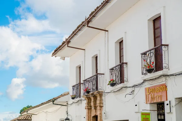 POPAYAN, COLOMBIA - 31 DE MARZO DE 2018: Vista al aire libre de edificios coloniales blancos con balcón con flores en una maceta en la ciudad de Popayan durante el hermoso día soleado —  Fotos de Stock