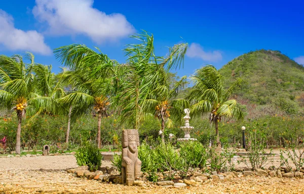 Outdoor view of some stoned structures close to a coconut palm trees in a caribbean Beach in beautifunny sunny day and blue sky — Stock Photo, Image